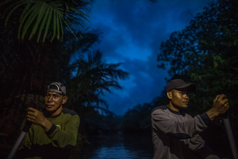 Rangers paddling down a river at night in search of Javan Rhino in Ujung Kulon National Park, Java (Photo by Robin Moore, Re:wild).