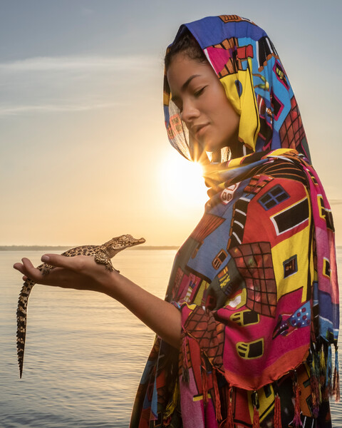 Global Wildlife Ambassador Cenit Nadir holding a young Cuban Crocodile at sunrise in Zapata Swamp.